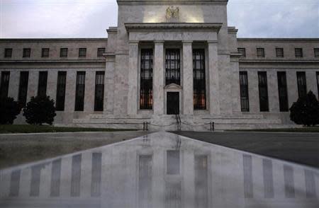 The facade of the U.S. Federal Reserve building is reflected on wet marble during the early morning hours in Washington, July 31, 2013. REUTERS/Jonathan Ernst