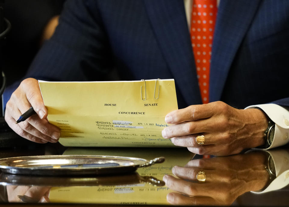 Washington Gov. Jay Inslee pauses as he holds House Bill 1240, which prohibits the manufacture, importation, distribution and sale of semi-automatic assault-style weapons in the state, before signing it into law, Tuesday, April 25, 2023, at the Capitol in Olympia, Wash. (AP Photo/Lindsey Wasson)