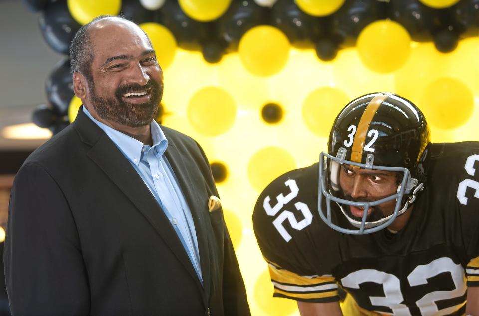 FILE - Former Pittsburgh Steelers running back Franco Harris stands next a statute of himself on Sept. 12, 2019, at Pittsburgh International Airport near Pittsburgh. (Nate Guidry/Pittsburgh Post-Gazette via AP, File)