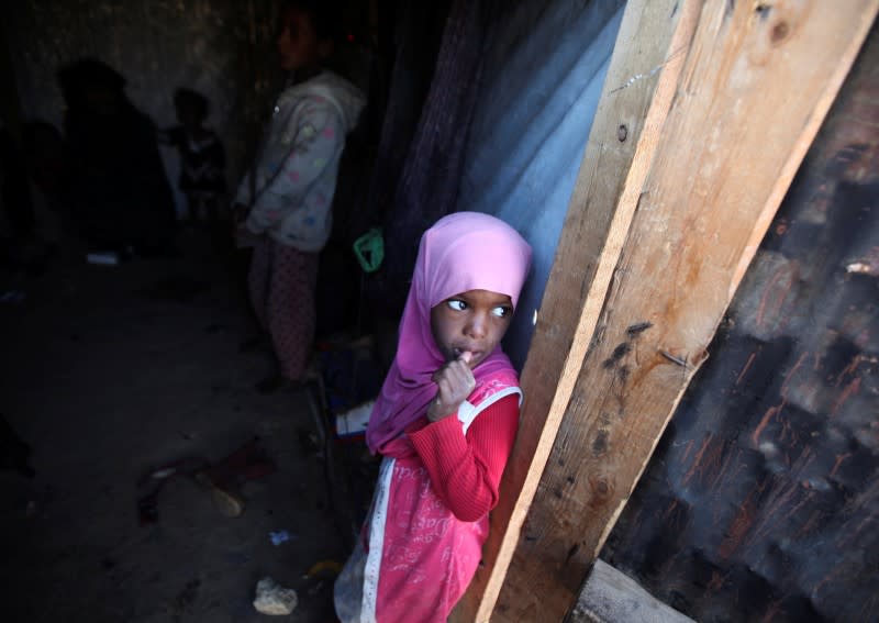 Girl stands in her family's hut at a camp for internally displaced people in Khamir of the northwestern province of Amran