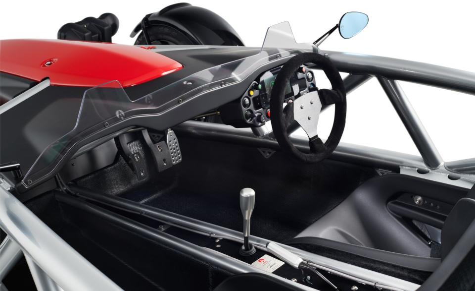<p>The steering wheel has a microfiber-wrapped rim, and behind it is a digital display screen set into a small console that contains all controls other than the pedals, gearshift, and parking brake.</p>