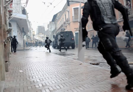 Riot police move towards demonstrators during a protest after Ecuadorian President Lenin Moreno's government ended four-decade-old fuel subsidies, in Quito