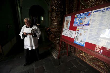 A priest walks at the entrance of the Cathedral in Quito, Ecuador July 4, 2015. REUTERS/Jose Miguel Gomez