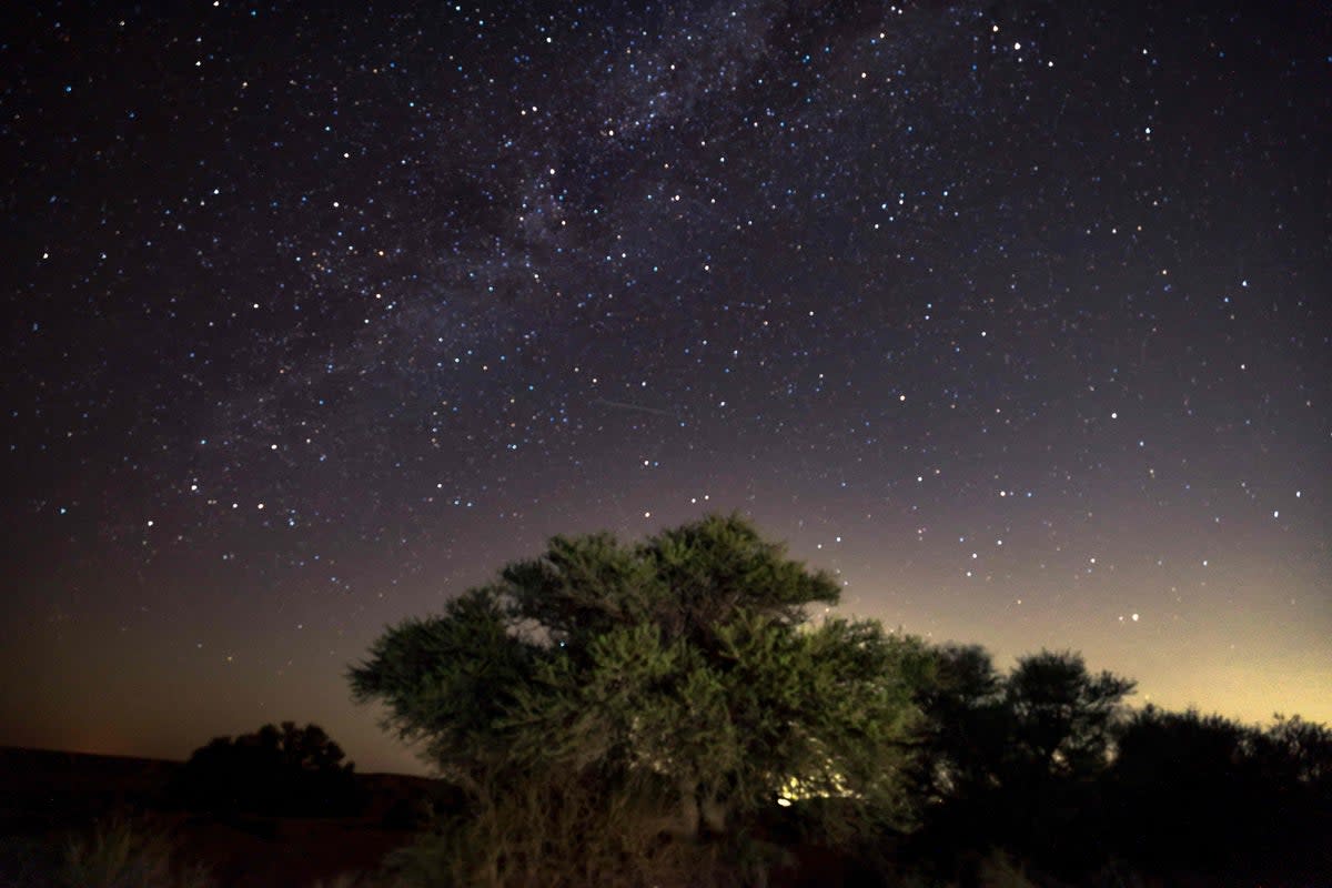 The Milky Way galaxy appears as a Perseid meteor streaks across the sky above a camping site in the southern israel Negev desert near the Israeli village of Faran early on 12 August  2023 (AFP via Getty Images)