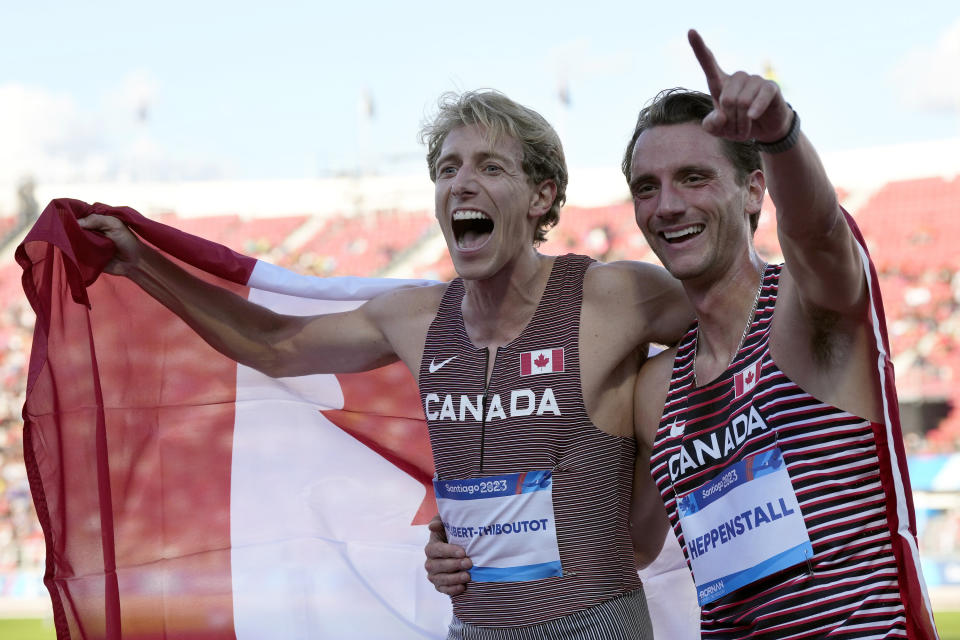 Canada's Robert Joseph Heppenstall, right, and Charles Philibert-Thiboutot celebrate after finishing second and first, respectively, in the men's 1,500 meters at the Pan American Games in Santiago, Chile, Thursday, Nov. 2, 2023. (Frank Gunn/The Canadian Press via AP)