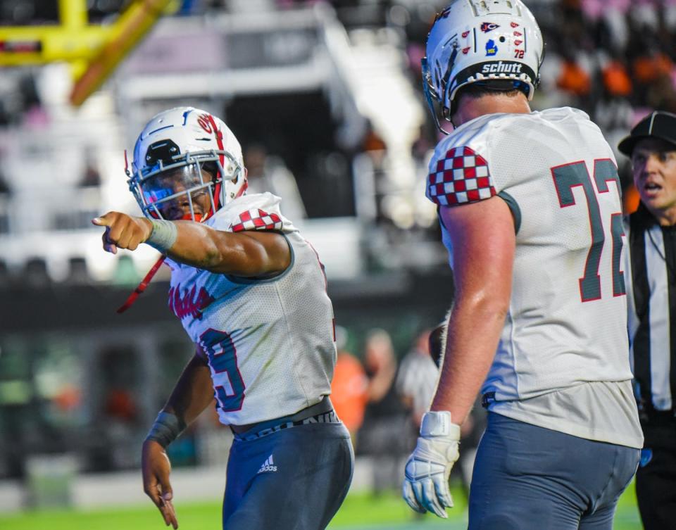 Gibbons running back Kamari Moulton (19) celebrates a tocuhdown alongside tackle Zack Boehly (72) during the Class 4A State Championship game between Cardinal Gibbons and Cocoa at DRV PNK Stadium in Fort Lauderdale.