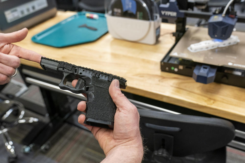 A handgun frame that has been printed on a 3D printer is held for a photograph at the Bureau of Alcohol, Tobacco, Firearms, and Explosives (ATF), National Services Center, Thursday, March 2, 2023, in Martinsburg, W.Va. Machine guns have been illegal in the U.S. for decades, but in recent years the country has seen a new surge of weapons capable of automatic fire. Small pieces of plastic or metal used to convert legal guns into homemade machine guns are helping to fuel gun violence. (AP Photo/Alex Brandon)