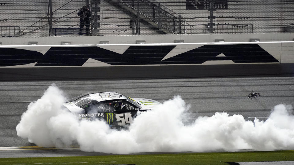 Ty Gibbs (54) celebrates with a burnout in front of the grandstands after winning the NASCAR Xfinity Series road course auto race at Daytona International Speedway, Saturday, Feb. 20, 2021, in Daytona Beach, Fla. (AP Photo/John Raoux)