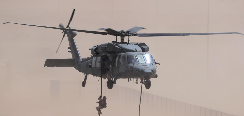 An Emirati soldier rappels out of a Sikorsky UH-60 Black Hawk during an exercise at an Emirati military base home to a Military Operations in Urban Terrain facility in al-Hamra, United Arab Emirates, Monday, March 23, 2020. The U.S. military held the major exercise Monday with Emirati troops in the UAE's far western desert at a facility designed to look like a Mideast city amid ongoing tensions with Iran. (AP Photo/Jon Gambrell)