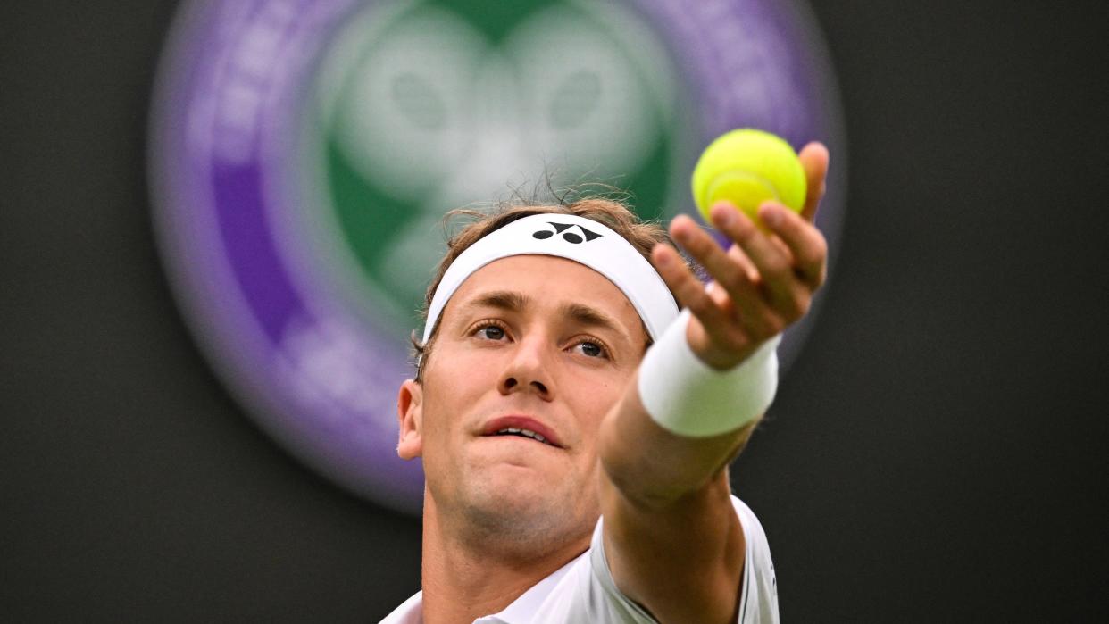  Casper Ruud serves the ball to France's Laurent Lokoli during their men's singles tennis match on the first day of the 2023 Wimbledon Championships at The All England Tennis Club  