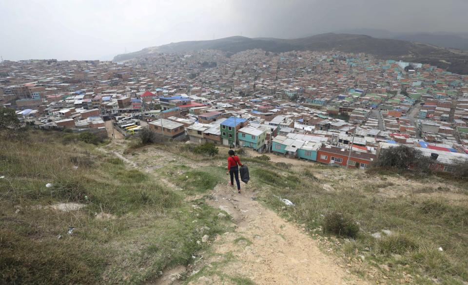 Una mujer camina por un sendero en la zona de Ciudad Bolívar, al sur de Bogotá, Colombia, en 2020. AP Photo / Fernando Vergara