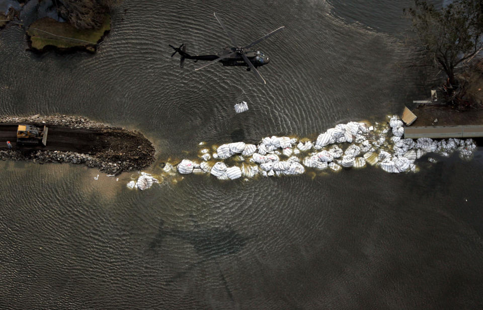 FILE - In this Sept. 5, 2005, file photo, a military helicopter drops a sandbag as work continues to repair the 17th Street canal levee in New Orleans, in the aftermath of Hurricane Katrina. After Hurricane Katrina’s monster storm surge roared ashore, Corps-constructed levees and floodwalls failed near Lake Pontchartain and along the Lower 9th Ward, inundating most of the city. (AP Photo/David J. Phillip, File)