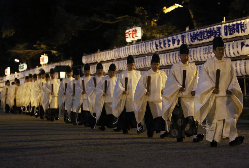 Shinto priests walk past lanterns after a ritual to usher in the New Year at the Meiji Shrine in Tokyo December 31, 2013. REUTERS/Yuya Shino (JAPAN - Tags: SOCIETY RELIGION)