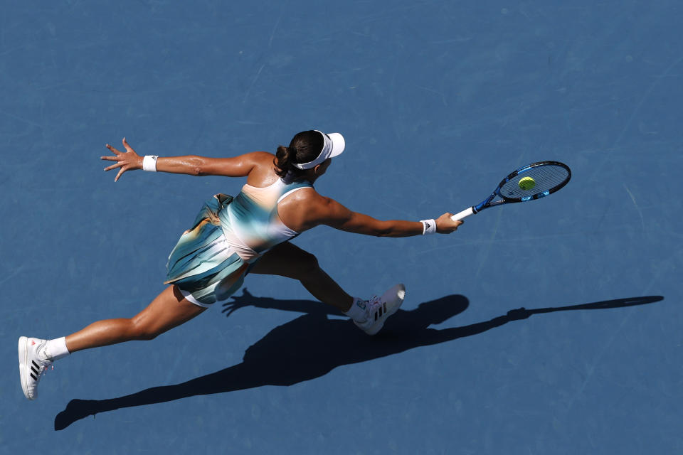 Garbine Muguruza of Spain plays a forehand return to Clara Burel of France during their first round match at the Australian Open tennis championships in Melbourne, Australia, Tuesday, Jan. 18, 2022. (AP Photo/Hamish Blair)