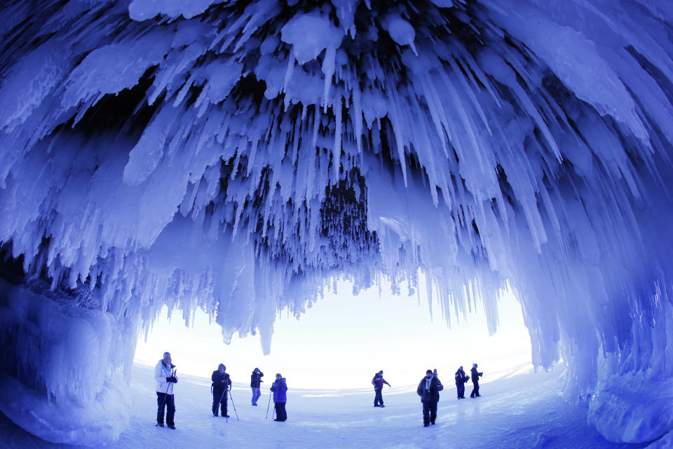 In this Feb. 2, 2014 photo, people visit the caves at Apostle Islands National Lakeshore in northern Wisconsin, transformed into a dazzling display of ice sculptures by the arctic siege gripping the Upper Midwest. The caves are usually accessible only by water, but Lake Superior’s rock-solid ice cover is letting people walk to them for the first time since 2009. (AP Photo/Minneapolis Star Tribune, Brian Peterson)