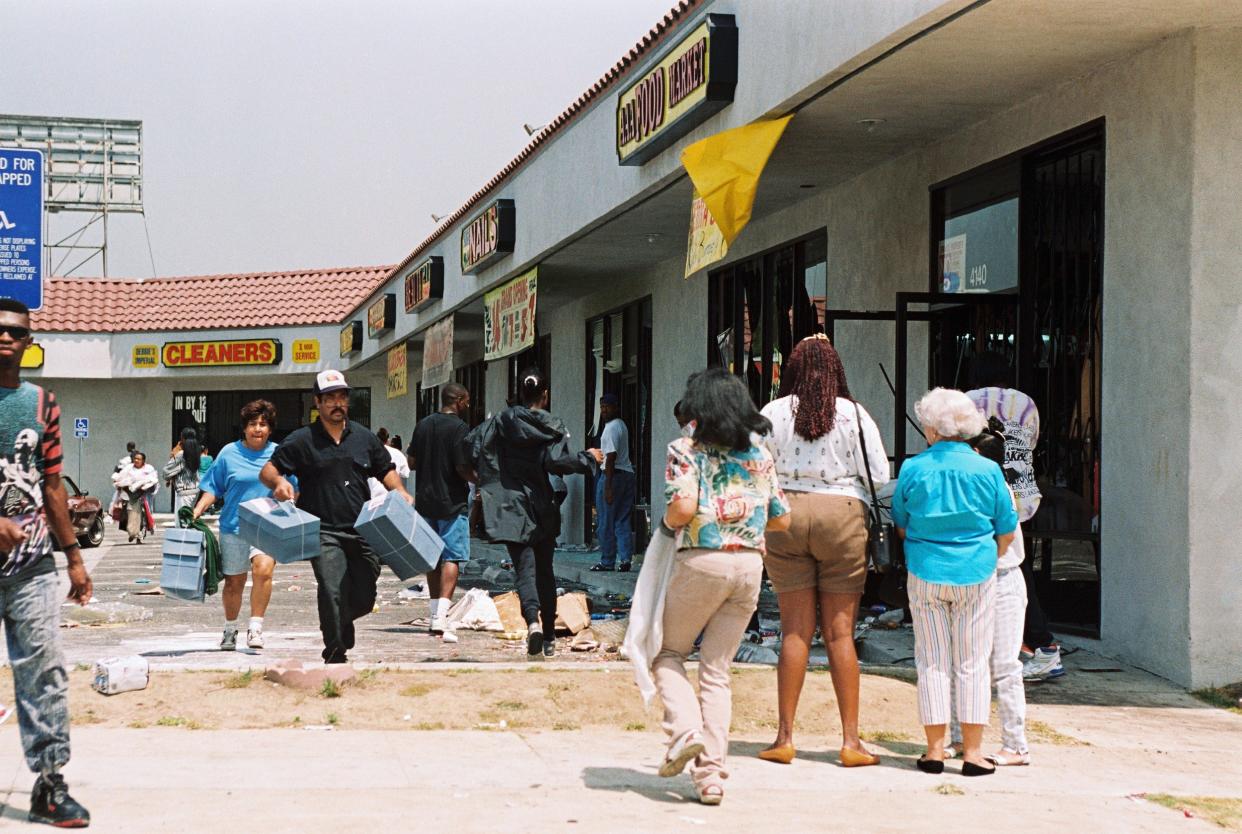 Looters, left, taking merchandise from a shopping center in Los Angeles