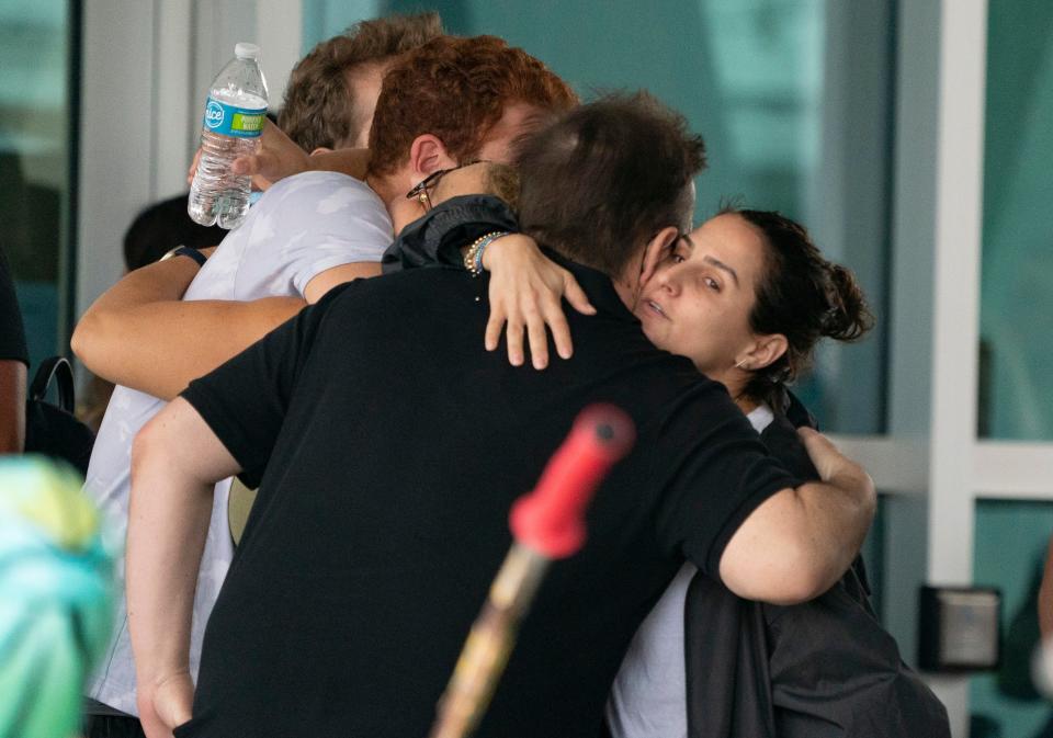 People hug outside the Surfside Community Center as they wait for news on June 25, 2021, in Surfside, Fla. The 12-story Champlain Towers South condo building partially collapsed Thursday in Surfside.