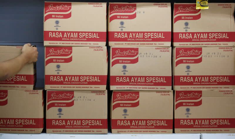 A worker arranges boxes of Indomie Special Chicken Flavour instant noodles, at a supermarket in Jakarta