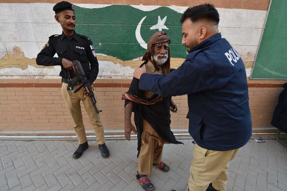 Pakistani security officials stand guard at a polling station, during general elections in Karachi (EPA)