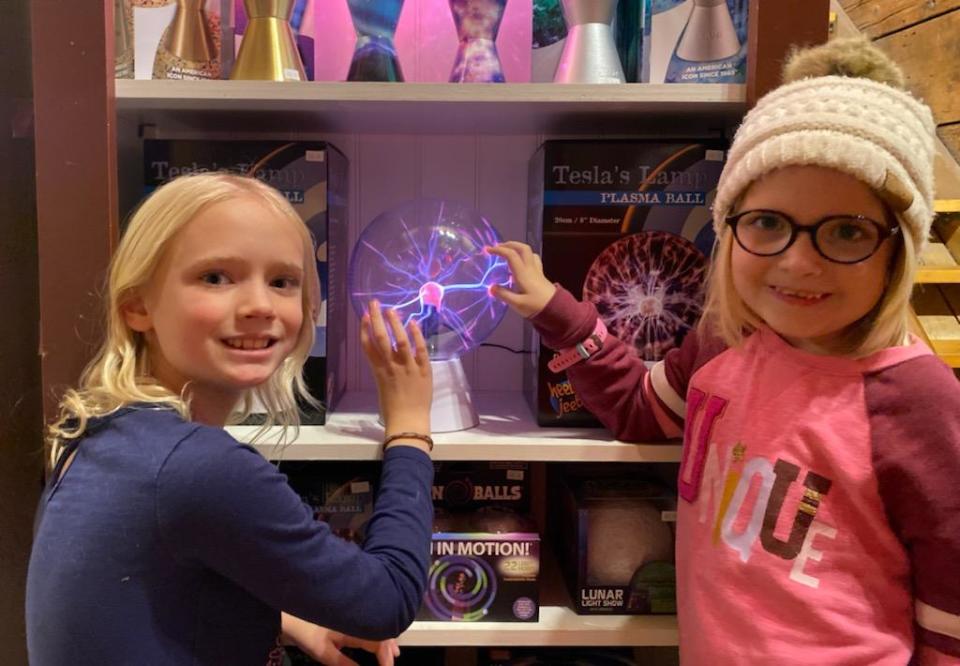 Hannah and Emily Buckhouse play with a Tesla plasma ball at The Smiley Barn toy store in Delafield.
