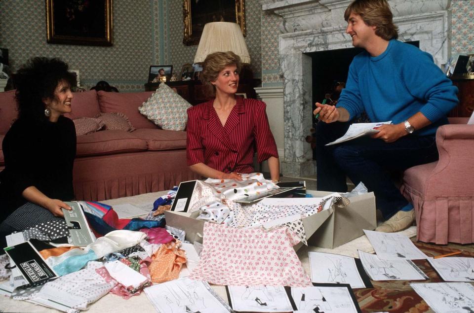 <p>Surrounded by designers David and Elizabeth Emanuel, Princess Diana considers designs and fabrics for an upcoming tour in the sitting room at Kensington Palace. </p>