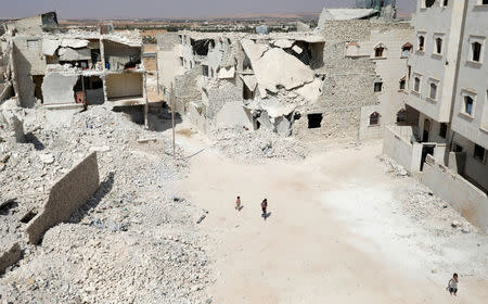 People walk near damaged buildings in the Syrian city of al-Bab, Syria September 20, 2017. REUTERS/Khalil Ashawi