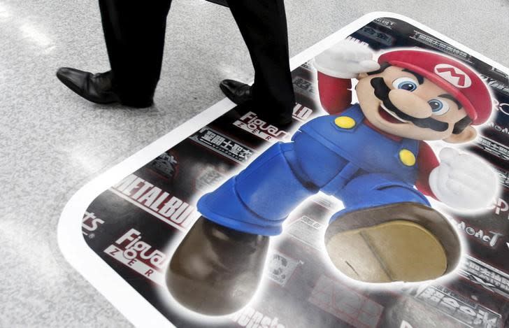 A man walks past an advertisement of "Mario", a character in Nintendo Co Ltd's "Mario Bros" video games, at an electronics retail store in Tokyo May 7, 2015. REUTERS/Toru Hanai