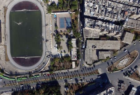 A general view taken with a drone shows buses parked outside the municipal stadium in the government-controlled area of Aleppo, as they wait to evacuate people wishing to leave besieged eastern Aleppo, Syria October 20, 2016. REUTERS/Abdalrhman Ismail