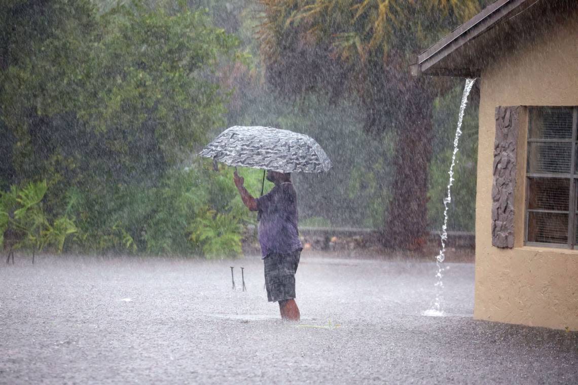 A man stops to take pictures of his flooded neighborhood along SW 3rd Street and SW 4th Ave in Dania Beach on Wednesday, April 12, 2023.