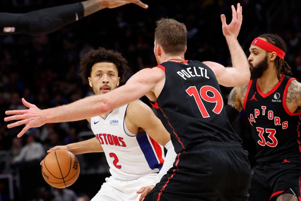 Detroit Pistons guard Cade Cunningham (2) dribbles while defended by Toronto Raptors center Jakob Poeltl (19) in the first half at Little Caesars Arena.