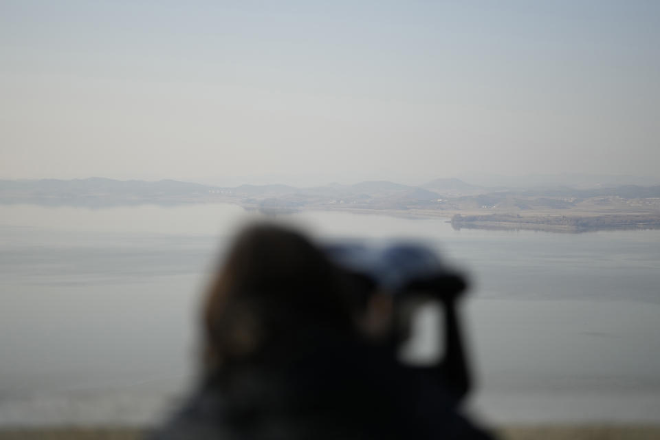 A visitor uses a pair of binoculars to see the North Korean side from the unification observatory, in Paju, South Korea, Tuesday, Nov. 21, 2023. North Korean leader Kim Jong Un said his country will launch three additional military spy satellites, build more nuclear weapons and introduce modern unmanned combat equipment in 2024, as he called for “overwhelming” war readiness to cope with U.S.-led confrontational moves, state media reported Sunday, Dec. 31, 2023.(AP Photo/Lee Jin-man)
