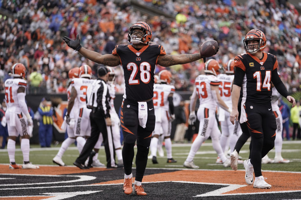 Cincinnati Bengals running back Joe Mixon (28) celebrates after a 3-yard touchdown during the first half of an NFL football game against the Cleveland Browns, Sunday, Dec. 29, 2019, in Cincinnati. Quarterback Andy Dalton (14) smiles as he looks on. (AP Photo/Bryan Woolston)