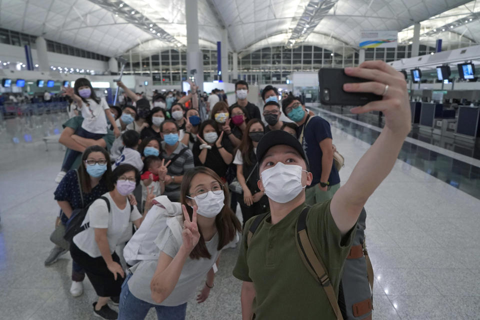 Mike Hui, right, takes a selfie of his family and friends before his departure to England, in Hong Kong airport on May 21, 2021. Until early April, Hui was a photojournalist for the Apple Daily, a pro-democracy newspaper that shut down following the arrest of five top editors and executives and the freezing of its assets under a national security law that China's ruling Communist Party imposed on Hong Kong as part of the crackdown. (AP Photo/Kin Cheung)