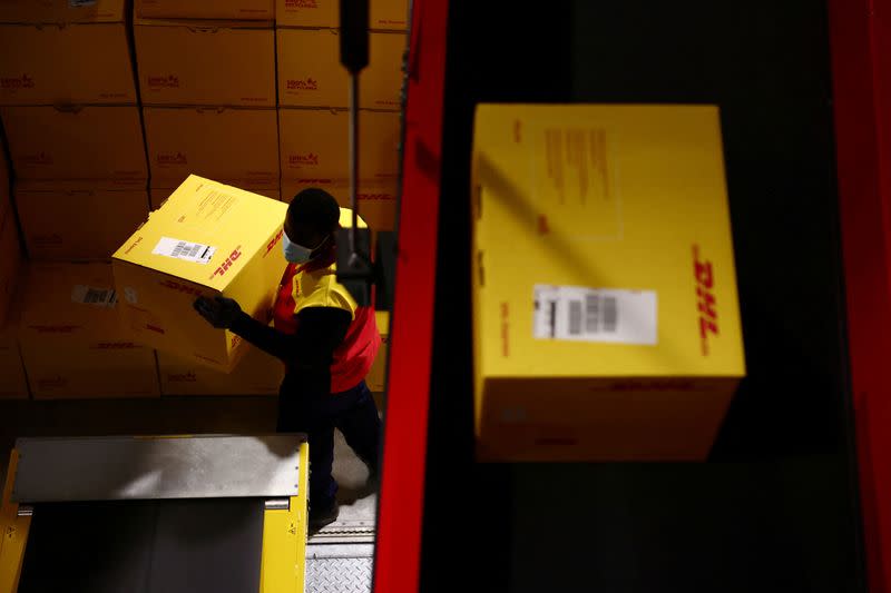 FILE PHOTO: An employee carries a DHL delivery package inside the new DHL Express hub near Paris