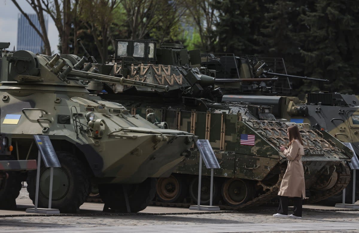 A woman examines armoured vehicles captured by Russian troops during the war in Ukraine during an exhibition on the Poklonnaya Hill (EPA)