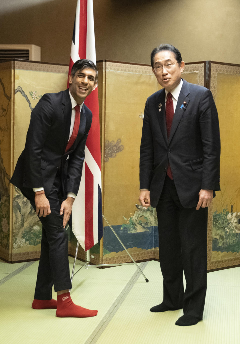 British Prime Minister Rishi Sunak shows off his socks to Japanese Prime Minister Fumio Kishida, which has the name of Kishida's favorite baseball team, Hiroshima Toyo Carp, on them, during their bilateral meeting in Hiroshima ahead of the G7 Summit in Japan, Thursday May 18, 2023. (Stefan Rousseau, Pool via AP)