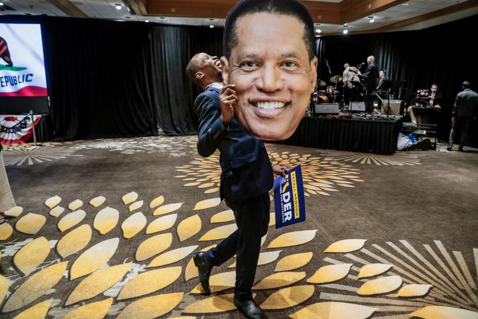 Sept. 14: Errol Webber carries a large cutout picture of Larry Elder in a room