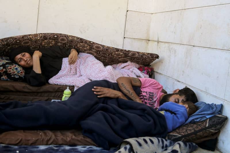 Relatives sleep on a sidewalk in Beirut after fleeing heavy Israeli airstrikes on Beirut's southern suburbs. Thousands of Lebanese and Syrian nationals fled southern Lebanon and the southern suburbs of Beirut after heavy Israeli airstrikes. Marwan Naamani/dpa