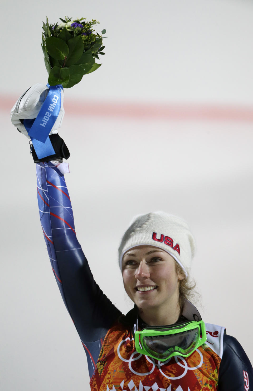 Women's slalom gold medal winner Mikaela Shiffrin of the United States holds up her bouquet at a flower ceremony at the Sochi 2014 Winter Olympics, Friday, Feb. 21, 2014, in Krasnaya Polyana, Russia.(AP Photo/Gero Breloer)