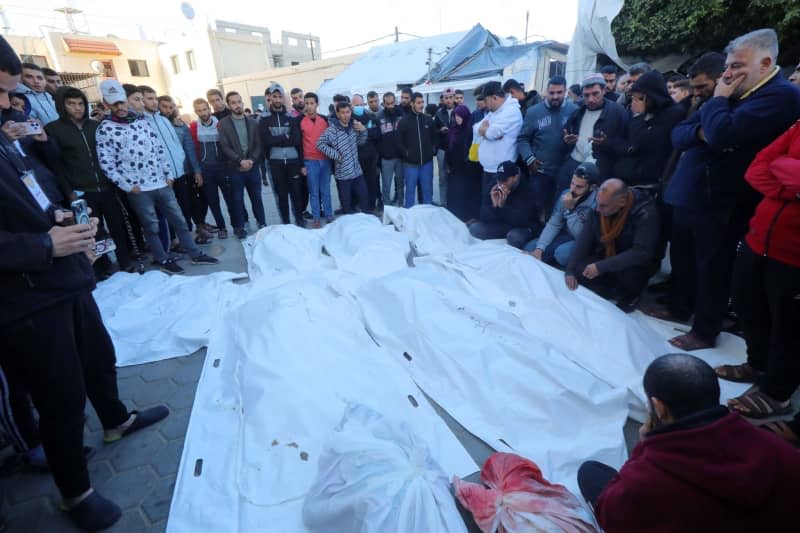 Relatives of Palestinians who died in Israeli attacks, mourn as they receive the dead bodies from the morgue of Al-Aqsa Hospital for burial. Naaman Omar/APA Images via ZUMA Press Wire/dpa