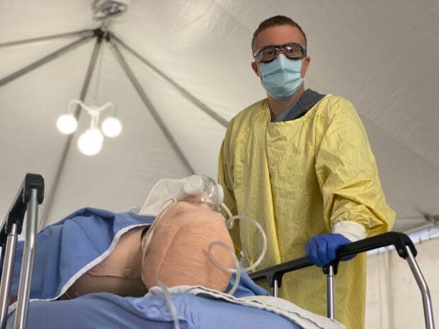 Brad Poechman, a registered nurse, participates in simulation training in a tent outside Toronto General Hospital.  (Talia Ricci/CBC - image credit)