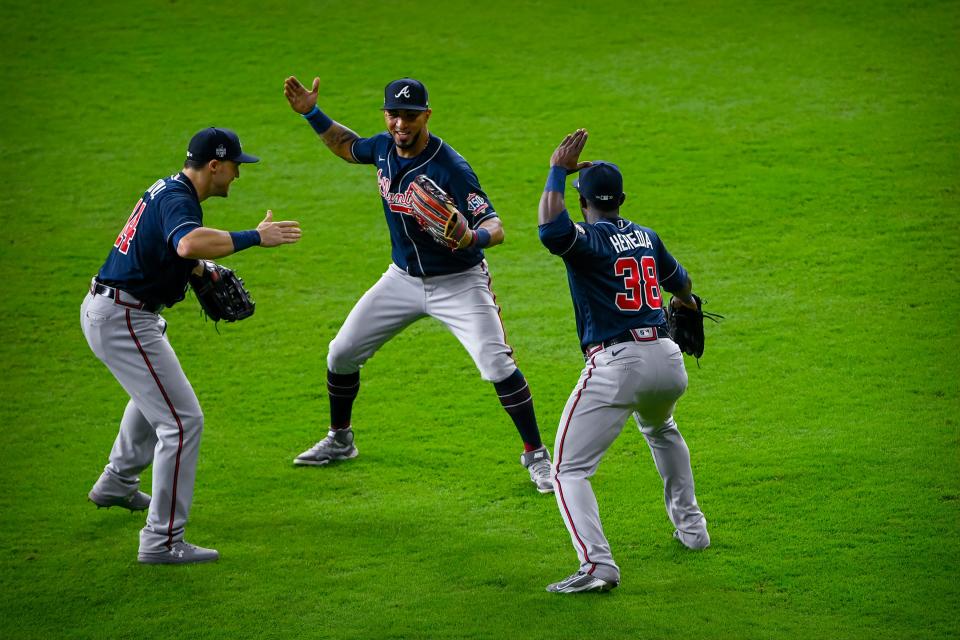 Adam Duvall, Eddie Rosario and Guillermo Heredia celebrate the Game 1 win.