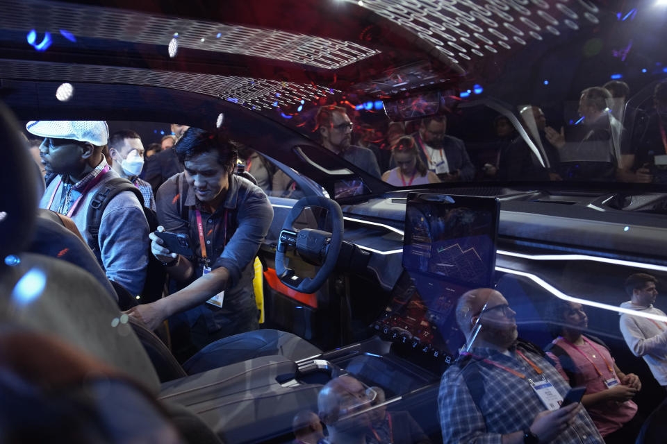 People look inside the Ram 1500 Revolution electric battery powered pickup truck after the Stellantis keynote at the CES tech show Thursday, Jan. 5, 2023, in Las Vegas. (AP Photo/John Locher)
