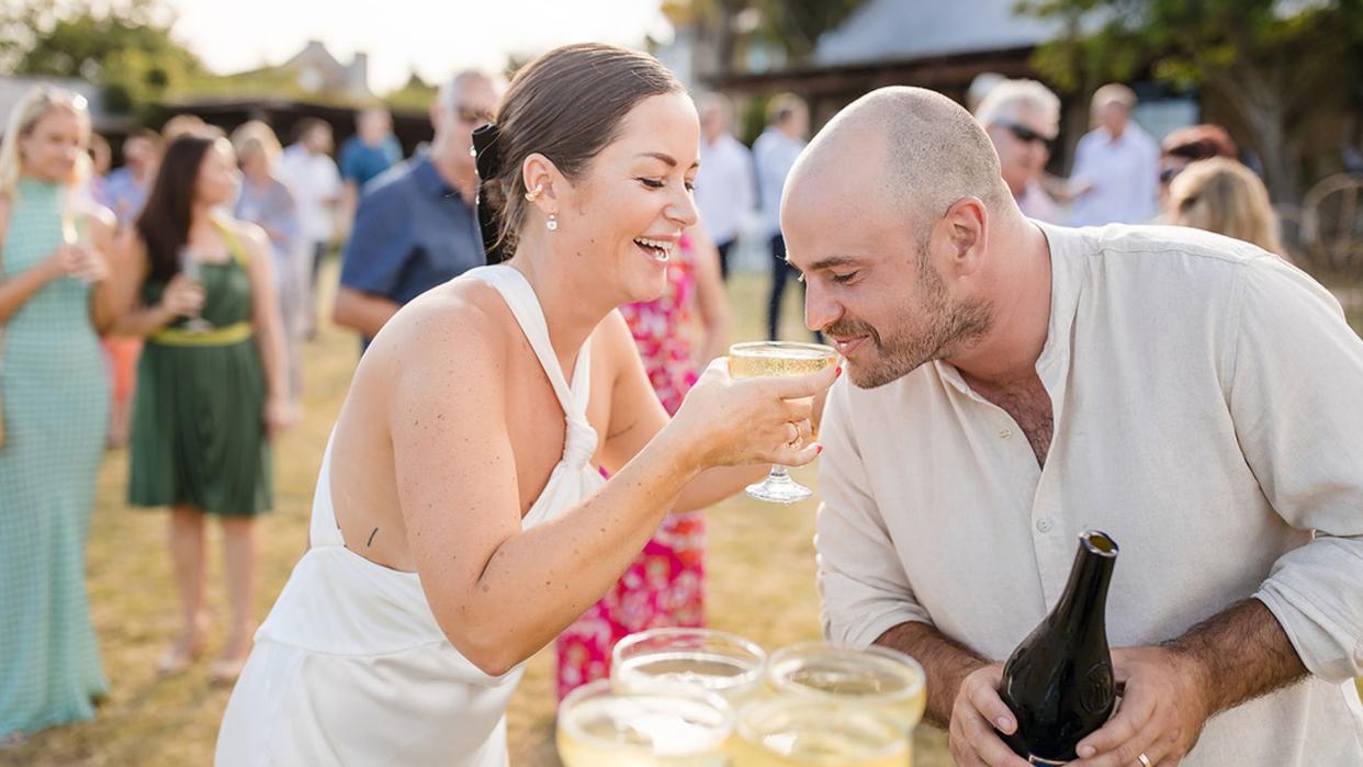 Man and woman drinking outside at wedding