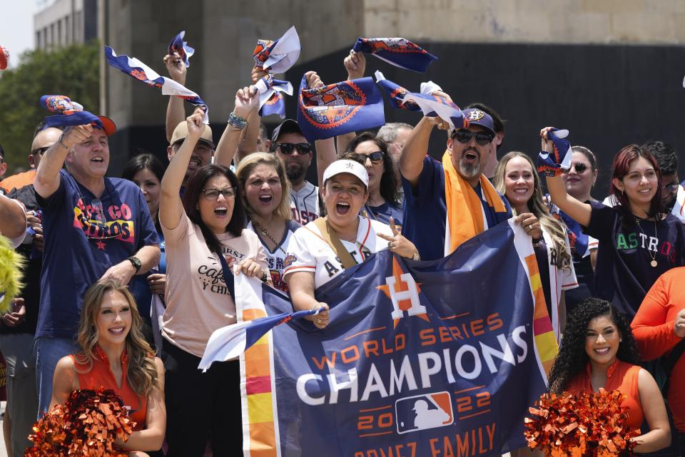 Houston Astros fans pose for a photo at the base of the Monument to the Revolution, in Mexico City, Thursday, April 25, 2024. The Houston Astros will face Colorado Rockies in two regular season game beginning Saturday, at Mexico City's Alfredo Harp Helú stadium. (AP Photo/Fernando Llano)