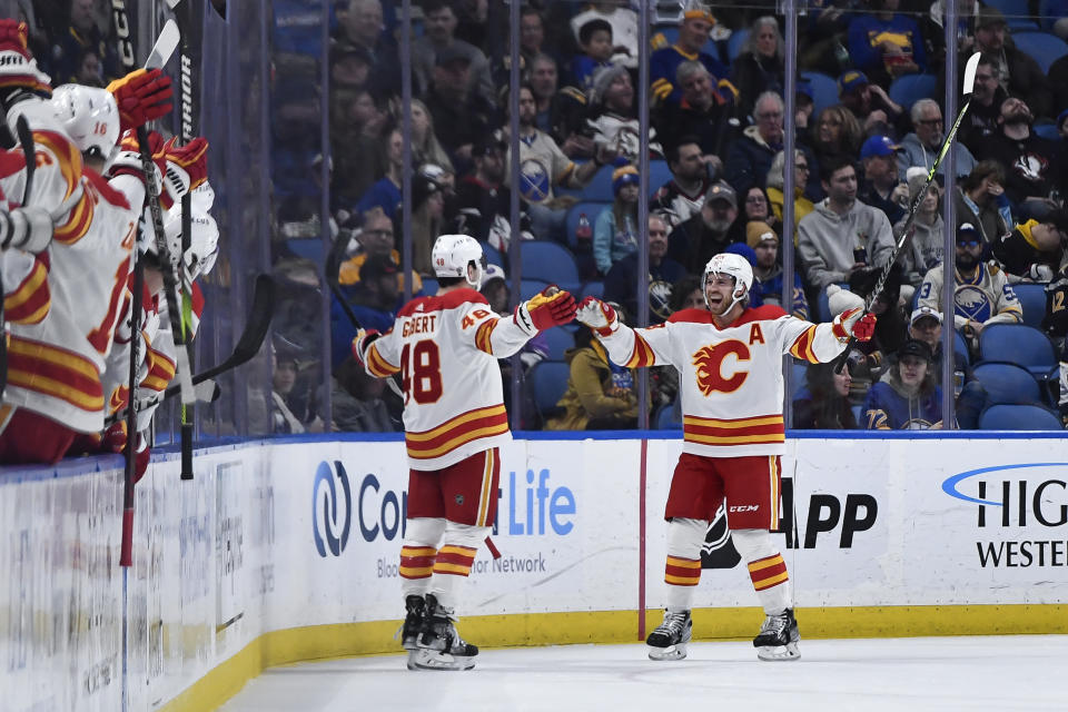 Calgary Flames defenseman Dennis Gilbert (48) celebrates with center Mikael Backlund (11) after scoring against the Buffalo Sabres during the second period of an NHL hockey game in Buffalo, N.Y., Saturday, Feb. 11, 2023. (AP Photo/Adrian Kraus)