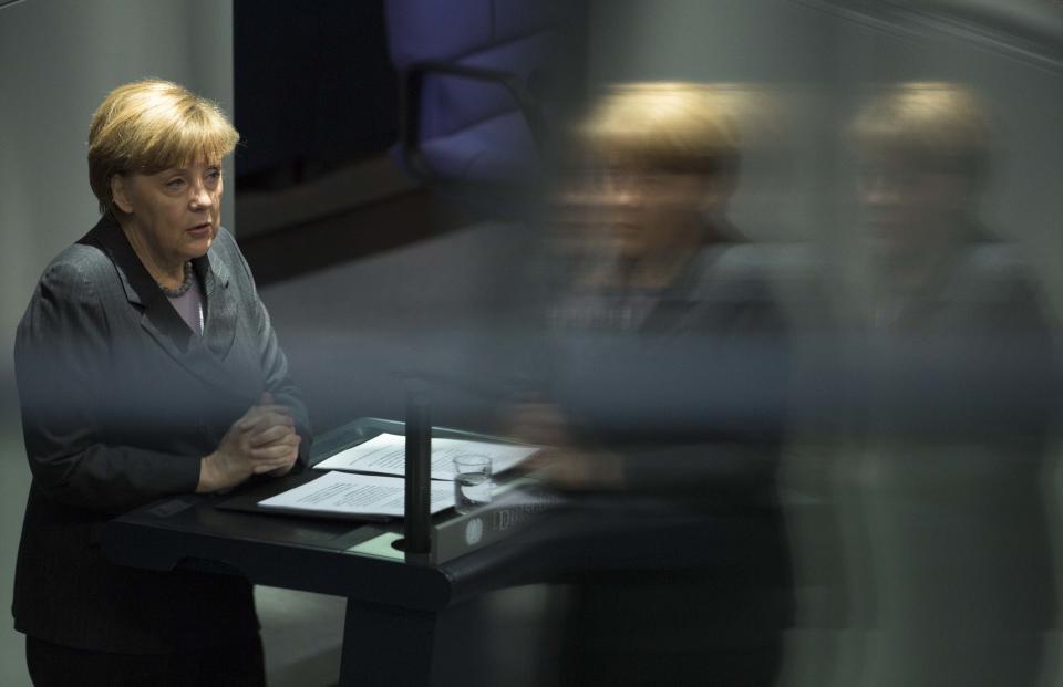 German Chancellor Angela Merkel delivers her speech, on the Ukrainian crisis at the parliament Bundestag in Berlin, Thursday, March 13, 2014. The photo istaken with reflection in glass pains of the visitors tribune. German Chancellor Angela Merkel warned Moscow on Thursday that if it continues its current course in the Ukraine crisis, Russia risks “massive” political and economic consequences. In an address to Parliament, Merkel told lawmakers the only way out of the crisis is through diplomacy and assured lawmakers that “the use of the military is no option.” (AP Photo/Markus Schreiber)