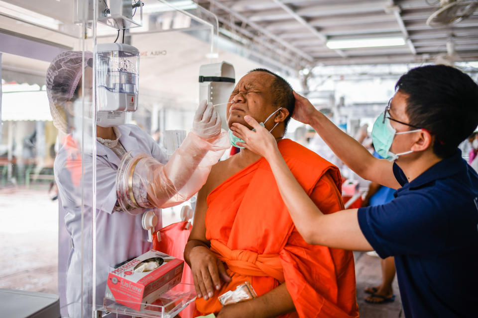 BANGKOK, THAILAND - 2020/05/30: A health worker collects a nasal swab sample from a Thai Buddhist monk to test for COVID-19 coronavirus at Wat Pho Temple in Bangkok. The Ministry of Public Health of Thailand has recorded 3,081 coronavirus cases, 2,963 recovered and 57 dead. (Photo by Amphol Thongmueangluang/SOPA Images/LightRocket via Getty Images)