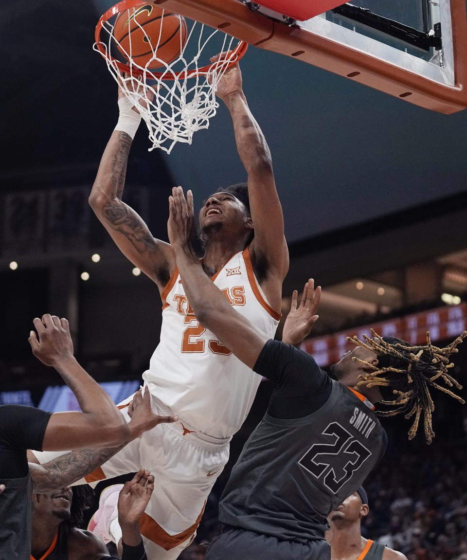 Texas forward Dillon Mitchell, left, drives to the basket over Oklahoma State forward Tyreek Smith, right, during the second half of an NCAA college basketball game in Austin, Texas, Tuesday, Jan. 24, 2023. (AP Photo/Eric Gay)