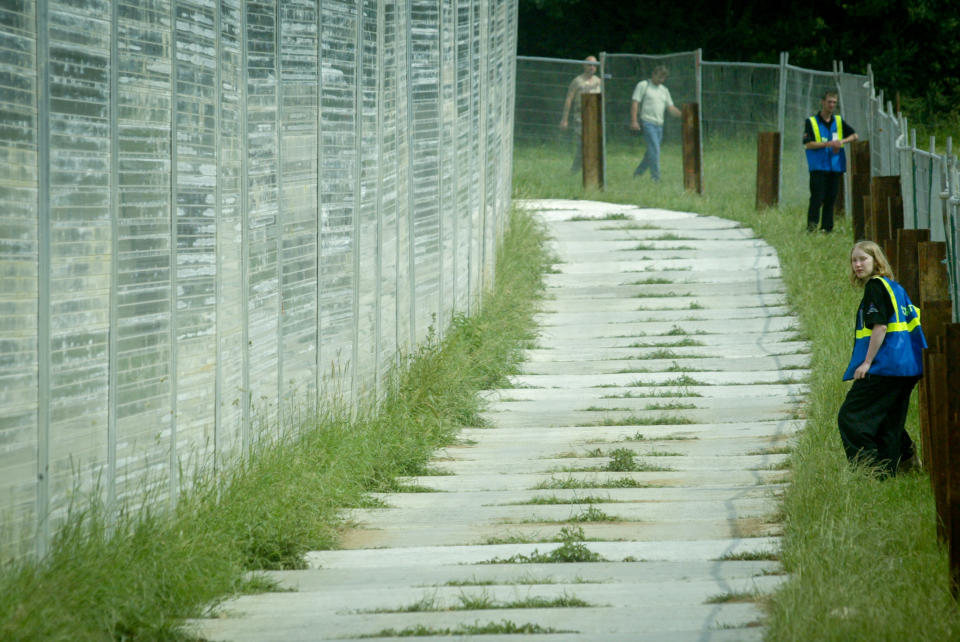 Stewards patrol the much improved super fence that has been erected during the 2003 Glastonbury Festival being held at Worthy Farm, in Pilton, Somerset on June 26, 2003 near Glastonbury, England. The festival founded in 1970 has grown into one of the largest outdoor green field festivals in the world.